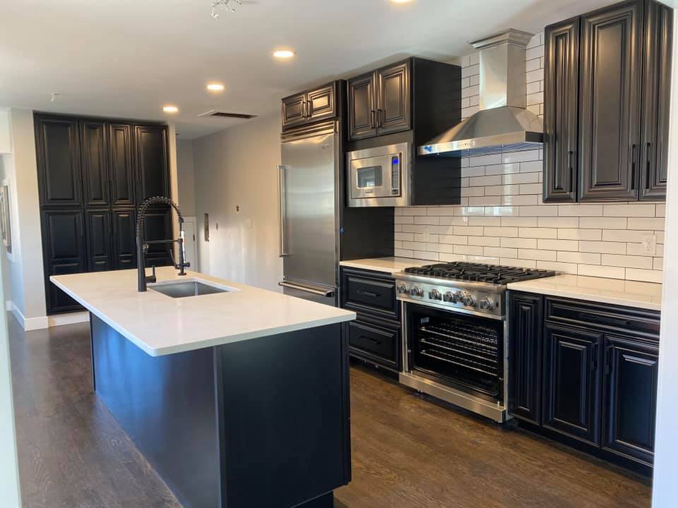 Luxury dark kitchen with quartz island after post-construction clean