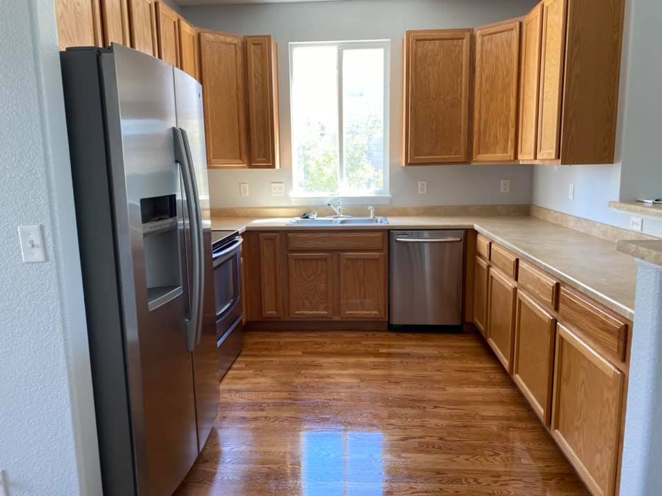 Oak cabinet kitchen with gleaming hardwood floors after residential clean